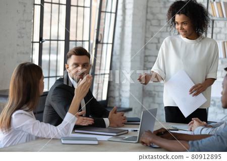 Smiling biracial businesswoman interact with colleague at meeting Smiling biracial businesswoman interact with colleague at meeting 80912895