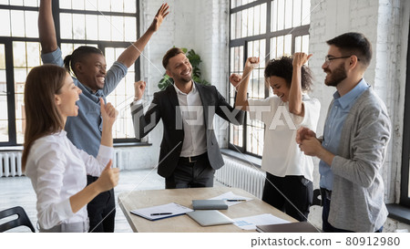 Excited multiracial employees celebrate shared team victory Excited multiracial employees celebrate shared team victory 80912980