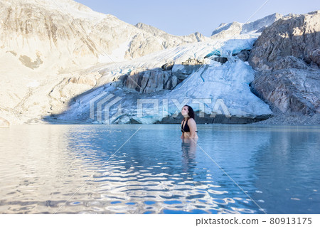 Adventurous White Caucasian Adult Woman Swimming in Ice Cold Glacier Lake 80913175