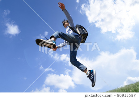 Boy jumping under the blue sky 80913587