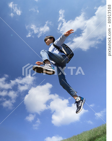 Boy jumping under the blue sky 80913588