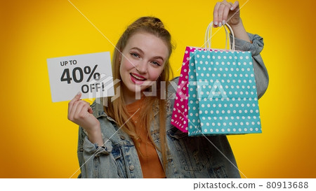 Cheerful teen girl showing shopping bags and Up To 40 Percent Off inscriptions banner, Black Friday 80913688