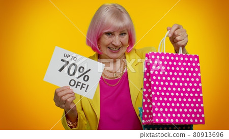 Elderly granny woman showing shopping bags and Up To 70 Percent Off inscriptions text, Black Friday 80913696