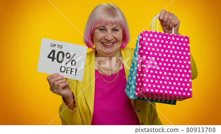 Elderly granny woman showing shopping bags and Up To 40 Percent Off inscriptions text, Black Friday 80913708