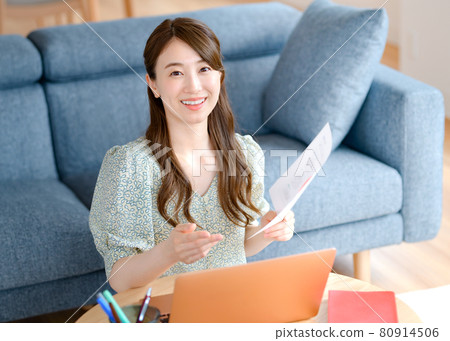 一位年輕的女商人在客廳遠程辦公 一位年輕的女商人在客廳遠程辦公 80914506