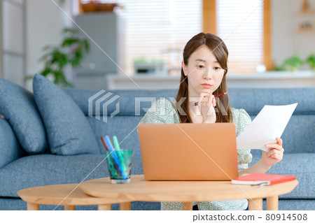 A young business woman teleworking in her living room 80914508