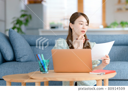 一位年輕的女商人在客廳遠程辦公 一位年輕的女商人在客廳遠程辦公 80914509