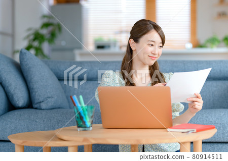 一位年輕的女商人在客廳遠程辦公 一位年輕的女商人在客廳遠程辦公 80914511