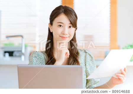 Young business woman teleworking in front of the kitchen 80914688