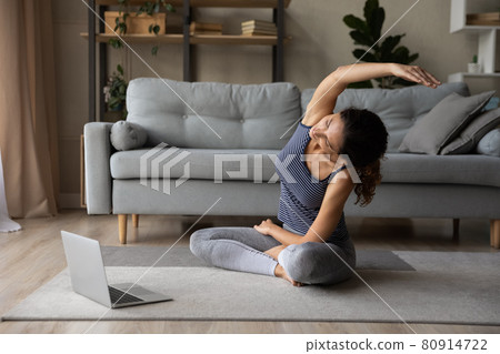 Woman in sportswear practicing yoga online at home, watching webinar Woman in sportswear practicing yoga online at home, watching webinar 80914722