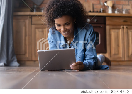 Smiling biracial woman use tablet talk on webcam call Smiling biracial woman use tablet talk on webcam call 80914730
