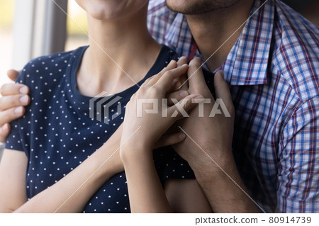 Close up shot of young couple hugging at window Close up shot of young couple hugging at window 80914739