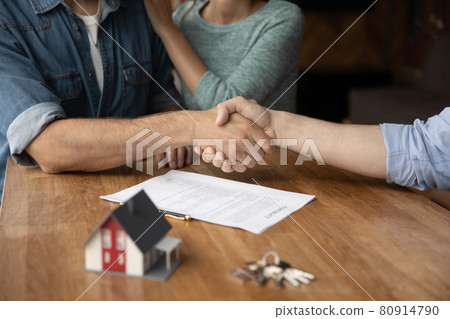 Couple of customers and real estate broker giving handshakes 80914790