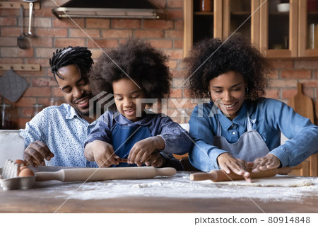 Happy biracial family with kid cooking together at home 80914848