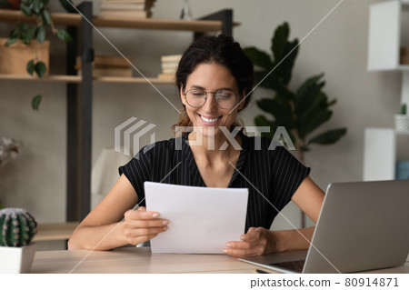 Close up smiling businesswoman in glasses reading letter, pleasant news 80914871