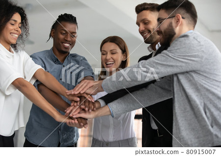 Excited diverse employees stack hands celebrate success Excited diverse employees stack hands celebrate success 80915007