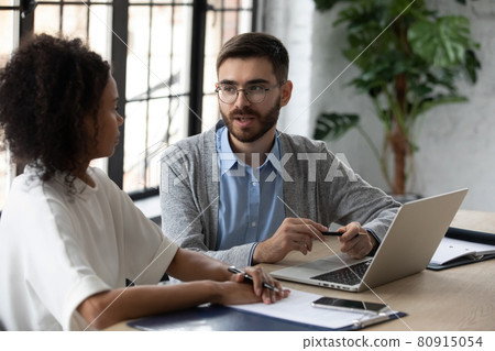 Diverse employees work together on laptop in office Diverse employees work together on laptop in office 80915054