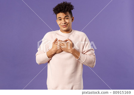 Portrait of touched silly young man left speechless and flattered, sobbing as being hit right into heart with dear warm words and praises, pleased standing purple background 80915169