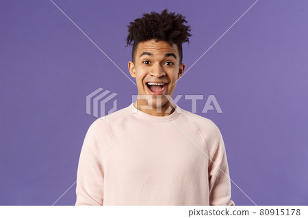 Close-up portrait of enthusiastic, excited and surprised hispanic guy hear amazing news, open mouth beaming smile from amazement and joy, rejoicing glad for friend achievement, purple background 80915178