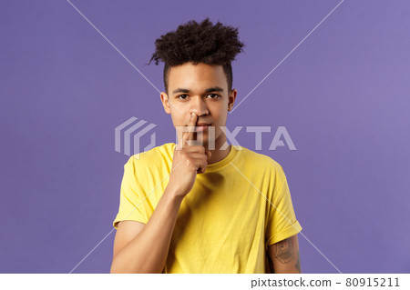 Close-up portrait of funny and unappropriate young hispanic teenage guy picking nose with finger, smiling and looking at camera, standing purple background, have bad habit Close-up portrait of funny and unappropriate young hispanic teenage guy picking nose with finger, smiling and looking at camera, standing purple background, have bad habit 80915211