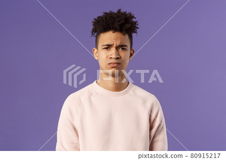 Close-up portrait of skeptical and gloomy, disappointed hispanic young man frowning upset, feel uneasy about bad idea, grimacing with disapproval, standing unhappy purple background Close-up portrait of skeptical and gloomy, disappointed hispanic young man frowning upset, feel uneasy about bad idea, grimacing with disapproval, standing unhappy purple background 80915217