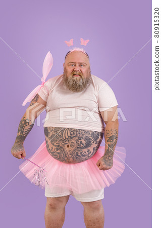 Funny brutal plus size man in fairy costume with magic stick and wings on purple background 80915320