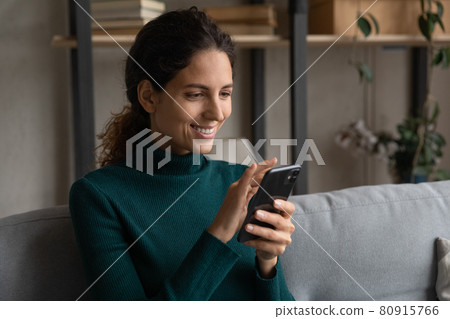 Close up happy young woman using smartphone, relaxing on couch 80915766