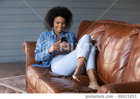 Happy African American woman relax using smartphone gadget Happy African American woman relax using smartphone gadget 80915853