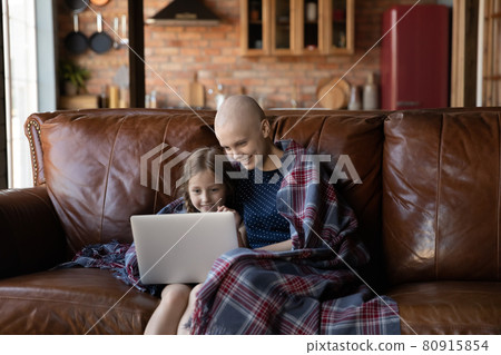 Happy ill mom and daughter relaxing on sofa at home 80915854