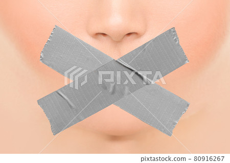 Woman silenced with adhesive duct tape covering closed mouth. Censorship, shut down of freedom of speech. Face nose and lips Woman silenced with adhesive duct tape covering closed mouth. Censorship, shut down of freedom of speech. Face nose and lips 80916267