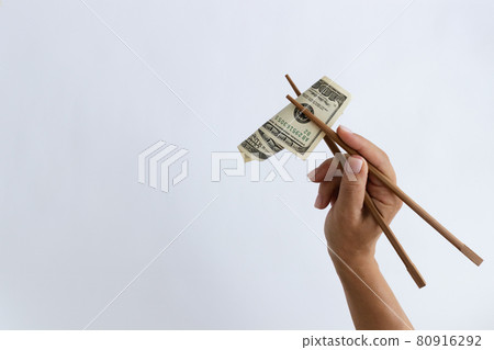 Dollars in a timber chopstick on a white with a copy space. Dollars in a timber chopstick on a white with a copy space. 80916292