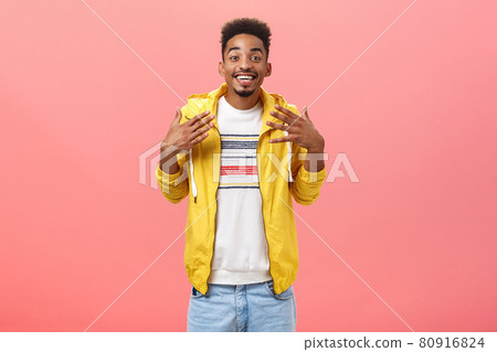 Studio shot of pleased positive dark-skinned guy with beard being charmed and excited with great fabulous news shaking palms near chest and smiling broadly from excitement over pink wall 80916824