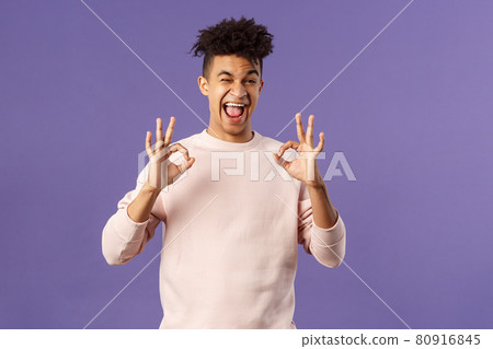 Portrait of chill young relaxed handsome man assure everything good, saying all okay, smiling and winking, recommend awesome product or online shop, leave positive feedback, purple background 80916845