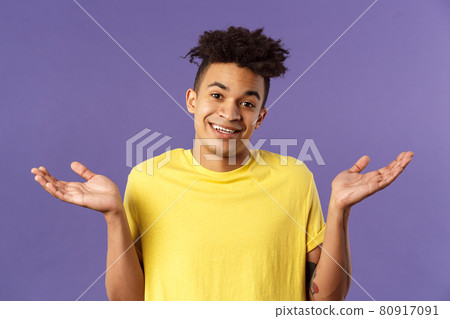 No big deal. Close-up portrait of carefree, unbothered friendly-looking young man enjoying weekends, have no worries, cant tell anything, being clueless and unaware, shrugging with sorry smile 80917091