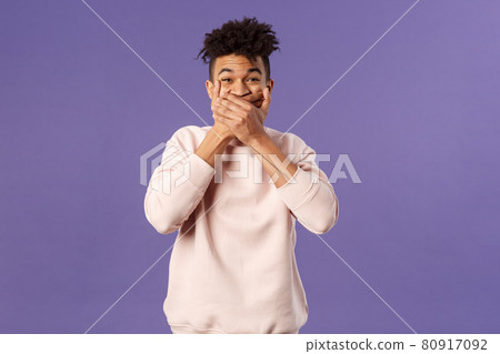 Portrait of amused, funny and carefree male student fooling around during class lecture, giggle, trying not laugh out loud so shut his mouth with hands, chuckle over hilarious joke Portrait of amused, funny and carefree male student fooling around during class lecture, giggle, trying not laugh out loud so shut his mouth with hands, chuckle over hilarious joke 80917092