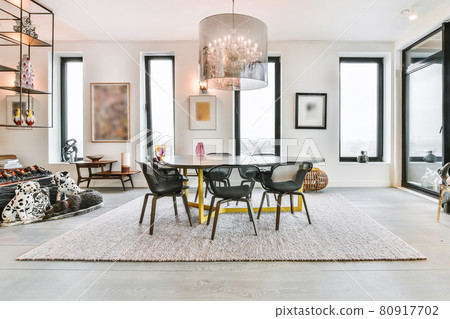 Spacious dining room with stylish table and chairs in modern apartment Spacious dining room with stylish table and chairs in modern apartment 80917702