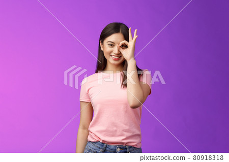 friendly cheerful young asian lady enjoy perfect summer day, show okay ok sign on eye, look through finger-circle, stand purple background joyful, recommend good place, feel excellent 80918318