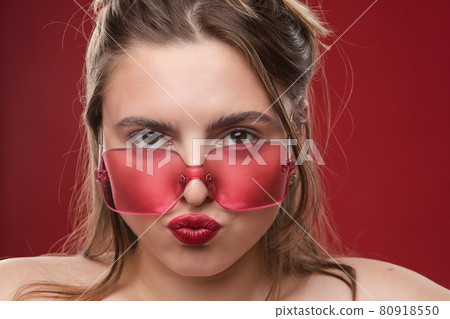 Portrait of lovely blonde woman with red 80918550