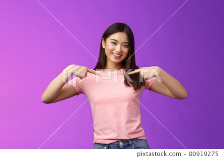 Active energized friendly tender asian stylish girl introduce herself, pointing chest proudly, smiling boastful, describe own achievements, bragging accomplishments, stand pleased purple background 80919275