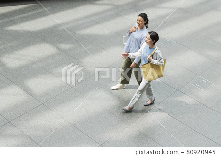 Two women walking in the building 80920945
