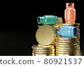 LPG or propane gas tank in the shape of a cylinder placed on a pile of gold coins. The concept of the cost of using cooking gas and the concept of income of a gas business. 80921537