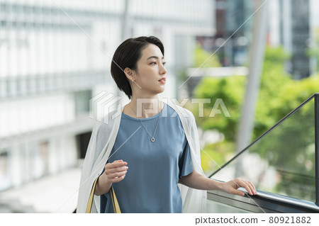 A woman riding an escalator A woman riding an escalator 80921882