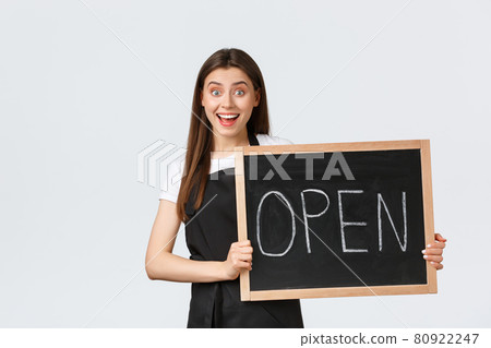 Grocery store employees, small business and coffee shops concept. Excited and cheerful cute female barista invite guests come enjoy drinks, showing we are open sign, stand white background 80922247