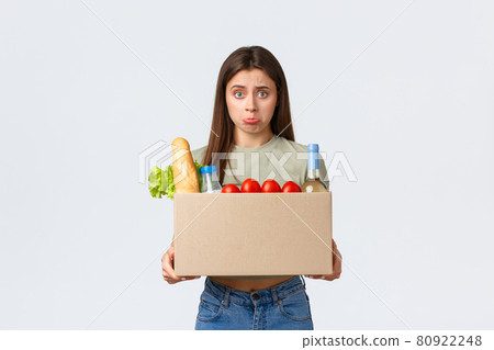 Online home delivery, internet orders and grocery shopping concept. Disappointed female customer receive wrong order of groceries, looking upset inside box and pouting, stand white background Online home delivery, internet orders and grocery shopping concept. Disappointed female customer receive wrong order of groceries, looking upset inside box and pouting, stand white background 80922248