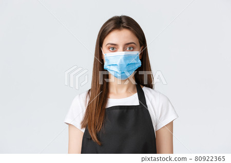 Covid-19 social distancing, cafe employees, coffee shops and coronavirus concept. Close-up of female barista in medical mask, follow all preventing virus measures, serving food to customers Covid-19 social distancing, cafe employees, coffee shops and coronavirus concept. Close-up of female barista in medical mask, follow all preventing virus measures, serving food to customers 80922365