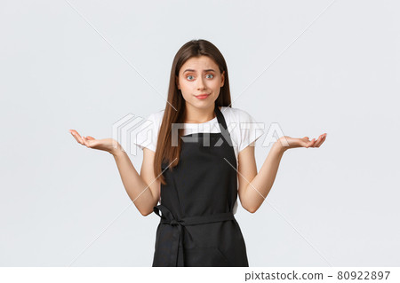 Grocery store employees, small business and coffee shops concept. Indecisive and clueless barista in black apron shrugging uncertain. Saleswoman having no idea what say Grocery store employees, small business and coffee shops concept. Indecisive and clueless barista in black apron shrugging uncertain. Saleswoman having no idea what say 80922897