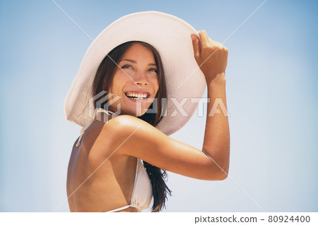 Beach hat Asian bikini woman enjoying sun wearing fashion white hat for solar protection skin care on summer vacation holidays. Young happy people lifestyle 80924400