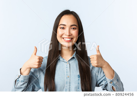 Lifestyle, people emotions and beauty concept. Cheerful friendly-looking asian girl smiling happy, show thumbs-up in approval, agree and support friend choice, white background Lifestyle, people emotions and beauty concept. Cheerful friendly-looking asian girl smiling happy, show thumbs-up in approval, agree and support friend choice, white background 80924456