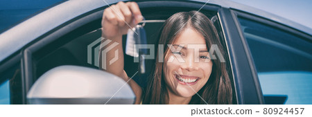 New Car driver young Asian woman driving automatic drive smiling showing new car keys banner panorama. New Car driver young Asian woman driving automatic drive smiling showing new car keys banner panorama. 80924457