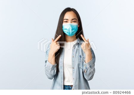 Social distancing lifestyle, covid-19 pandemic everyday life and leisure concept. Cheerful friendly-looking asian woman advice wear medical masks, pointing at herself as pefect example Social distancing lifestyle, covid-19 pandemic everyday life and leisure concept. Cheerful friendly-looking asian woman advice wear medical masks, pointing at herself as pefect example 80924466